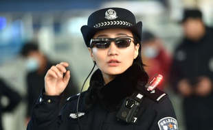 Photo d'une agente de police équipée des lunettes à reconnaissance faciale.