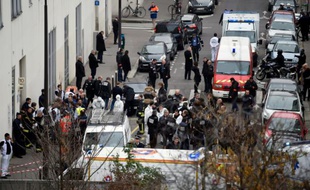 Des pompiers, des officiers de police et des médecins légistes devant le siège de Charlie hebdo après les attaques le 7 janvier 2015