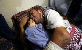 Yehya Hasan étreint le corps de sa fille Rahaf tuée, avec sa mère enceinte, par un raid aérien de l'armée israélienne dans la bande de Gaza, le 11 octobre 2015