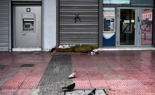 Un homme dort devant une banque du centre d'Athènes, le 13 mars 2015