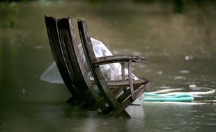 Une chaise dans un jardin inondé à Fismes, dans l'est de la France, le 15 juillet 2021, près des rives inondées de la rivière Ardre à la suite de fortes pluies.