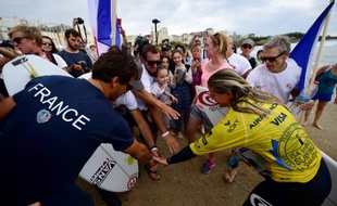 La championne (en jaune) a été accueillie triomphalement sur la plage par la délégation française.