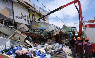 Des sauveteurs inspectent un bâtiment effondré à Digos, dans le sud des Philippines, le 31 octobre 2019.