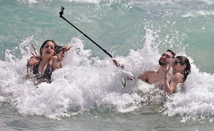 Touristes utilisant une perche à selfie, à Miami en mars 2015.