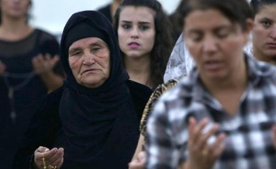 Des Chrétiens irakiens, qui ont fui les violences qu'ils subissaient dans le nord de Mossoul en Irak, prient dans l'église de MarAfram à Qaraqush, dans la province de Nineveh, le 19 juillet 2014