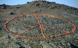 Photo montrant l'immense signe de la paix formé avec les gilets de sauvetage de milliers de migrants, sur une colline de Lesbos, le 1er janvier 2016