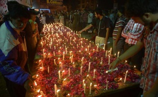 Des personnes rendent hommage aux victimes d'un attentat ayant fait 14 morts au Pakistan, le 15 mars 2015 à Karachi