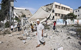Un Palestinien marche devant les ruines d'une école détruite par les bombardements à Gaza le 26 août 2014