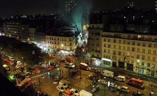 FRANCE, Paris : Les pompiers s'affairent autour du garage en flammes rue Riquet à Paris, le 16 novembre 2007. Deux pompiers sont ensevelis sous un mur qui s'est effondré lors du sinistre dû à l'explosion d'un véhicule.