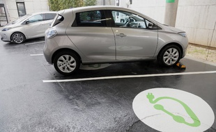 Une voiture électrique en charge sur une place de parking dédié à Paris.