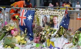 Portraits de Katrina Dawson (g) et Tori Johnson, tués lors de la prise d'otages dans un café à Sydney, au milieu de fleurs sur le site en hommage aux victimes, à Sydney, le 23 décembre 2014