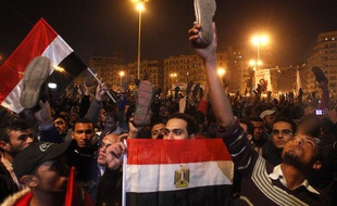 Les manifestants égyptiens brandissent leurs chaussures, alors qu'Hosni Moubarak s'exprime, pour montrer leur désapprobation place Tahrir, le 10 février 2011.