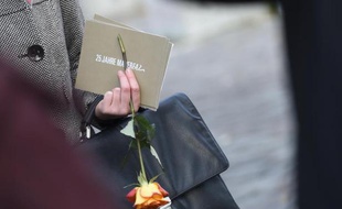 Une invitée, une rose à la main, des commémorations marquant le 25e anniversaire de la chute du Mur à Berlin, le 9 novembre 2014
