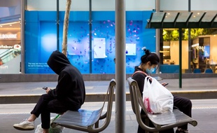 Des passagers attendent le tram à Melbourne, le 3 août 2020.