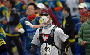 Un participant au marathon de Pékin portant un masque anti-pollution, le 19 octobre 2014 en Chine.