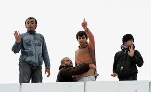 Des réfugiés syriens installés sur le toit d'un bâtiment sur le port de Calais le 4 octobre 2013
