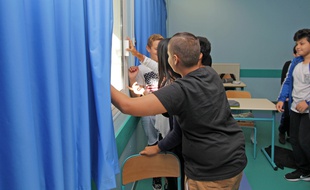 Des élèves du collège Capron, à Cannes, vérifient que les fenêtres de leur classe sont bien vérouillées, le lundi 3 octobre 2016, à l'ocassion d'un exxercice de prévention des inondations