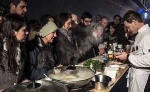 People wait to taste a dish during the inauguration of the first edition of the International Taste Biennial (BIG - Internationale du Gout) on January 24, 2015 in the Croix Rousse tunnel in Lyon, central-eastern France, where a 1,7km buffet has been set up as part of the International Catering, Hotel and Food Show (SIRHA - Salon international de la restauration, de l'hÙtellerie et de l'alimentation). The International Taste Biennial runs from January 24 to 28, 2015. AFP PHOTO / JEAN-PHILIPPE KSIAZEK