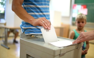 Un homme glisse son bulletin dans l'urne lors des élections en Saxe, dimanche 1er septembre 2019.
