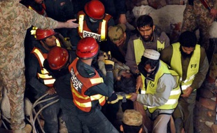 Des sauveteurs pakistanais portent une victime de l'effondrement d'une usine dans la zone industrielle de Lahore, le 4 novembre 2015
