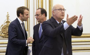 Le président François Hollande (c) parle avec le ministre de l'Economie Emmanuel Macron (g) derrière le ministre des Finances Michel Sapin pendant une réunion de l'OCDE au siège de l'organisation à Paris,le 17 octobre 2014
