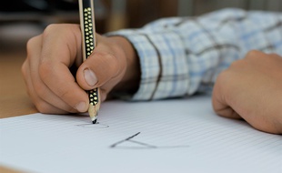 Un enfant en train d'écrire des lettres.