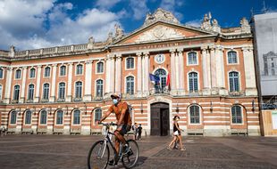 Un cycliste masqué dans le cadre de la lutte contre le coronavirus à Toulouse sur la place du Capitole.