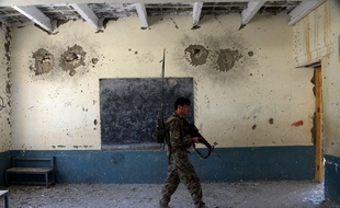Un membre des forces de sécurité afghanes dans une école utilisée par Daesh dans le district de Kot, dans la province de Nangarhâr, (est de l'Afghanistan)
