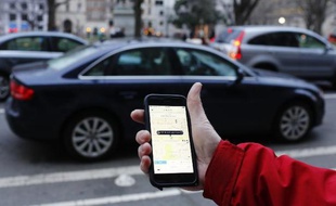 Une personne utilise l'application Uber sur son smartphone (illustration).