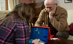 Un monsieur et sa fille joue à un jeu de société.