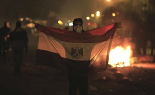 Un manifestant tient un drapeau égyptien lors d'émeutes au Caire (Egypte), le 2 février 2012.