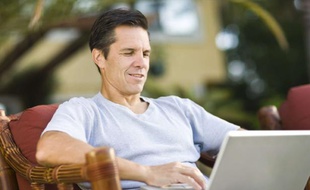 Un homme travaille sur son ordinateur portable.