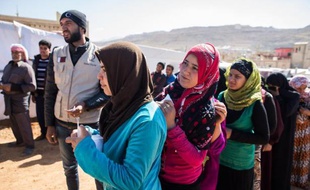 Des réfugiés syriens attendent une distribution de nourriture au camp d'Al-Masri, près de la ville libanaise d'Arsal, le 25 octobre 2014