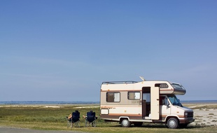 Illustration d'un camping-car garé près d'une plage en Bretagne.