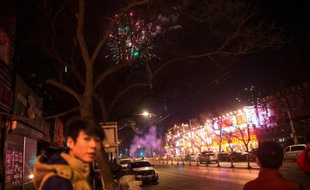 Des Chinois regardent les feux d'artifice tirés à la veille du nouvel an lunaire, à Pékin le 7 février 2016