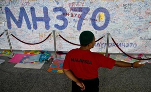Des messages à l'adresse des passagers du Boeing 777 de la Malaysia Airlines, sont écrits sur un mur le 17 mars 2014 à l'aéroport de Kuala Lumpur