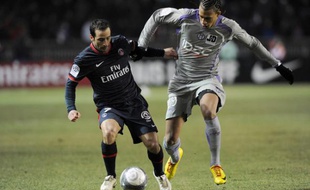Le Parisien Ludovic Giuly cherche à prendre de vitesse le Toulousain, Etienne Capoue (en gris), le 20 février 2010 au Parc des Princes.