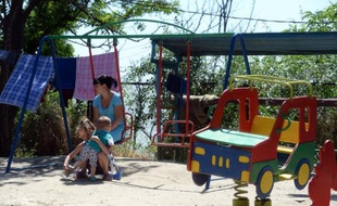 Une Ukrainienne et son enfant le 9 juin 2015 dans un camp de réfugiés au bord de la mer Azov dans la région de Rostov-sur-le-Don au sud de la Russie