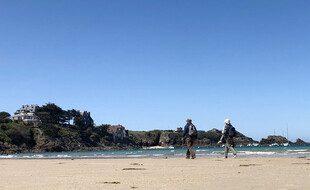 Un couple marche sur la grande plage de Saint-Lunaire, en Ille-et-Vilaine.