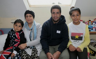 Des réfugiés irakiens Ali (2ème D) and Tahrir (2ème G) posent avec leurs enfants Abdullah (G) et Nabaa (D) dans leur centre d'accueil, le 16 septembre 2015 à Cergy, près de Paris