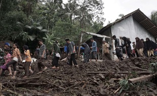 Les villageois marchent dans la zone touchée par des glissements de terrain à Java, en Indonésie. Dimanche 19 juin 2016.