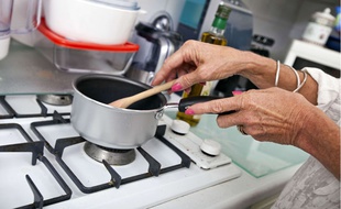 Une femme prépare à manger dans sa cuisine.