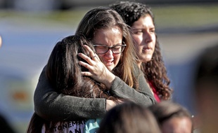 Une mère enlace sa fille après la fusillade qui a fait 17 morts dans un lycée de Parkland, en Floride, le 14 février 2018.