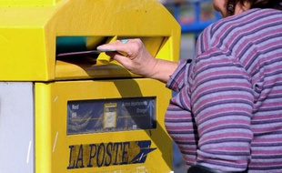 Une femme glisse une enveloppe dans une boite aux lettres, le 10 septembre 2013 à Lille (Photo illustration)