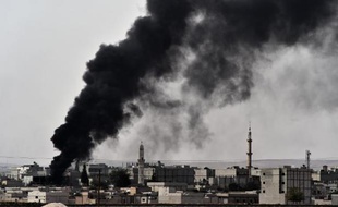 Epaisse fumée noire au-dessus de la ville de Kobané où les forces kurdes tentent de repousser les jihadistes de l'EI, le 10 octobre 2014 en Syrie