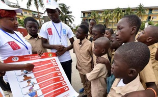 Des volontaires du Programme de développement de l'Onu (PNUD) expliquent à des écoliers les symptômes et les précautions à prendre contre le virus Ebola, le 15 septembre 2014 à Abidjan, en Côte d'Ivoire. (Photo illustration).