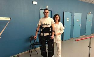 Adrien équipé de l'exosquelette avec Sophie, sa kiné.