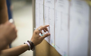Les lycéens cherchent leurs noms sur le tableau d'affichage des reçus au bac, le 7 juillet 2015 au lycée Georges Brassens à Paris