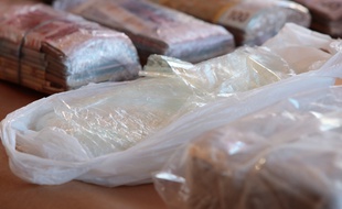 Photo d'illustration d'une saisie de cocaïne et de liasses de billets.