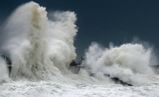 Illustration d'une tempête en Bretagne. De fortes vagues s'écrasent sur un mur du port de Lesconil dans le département du Finistère.